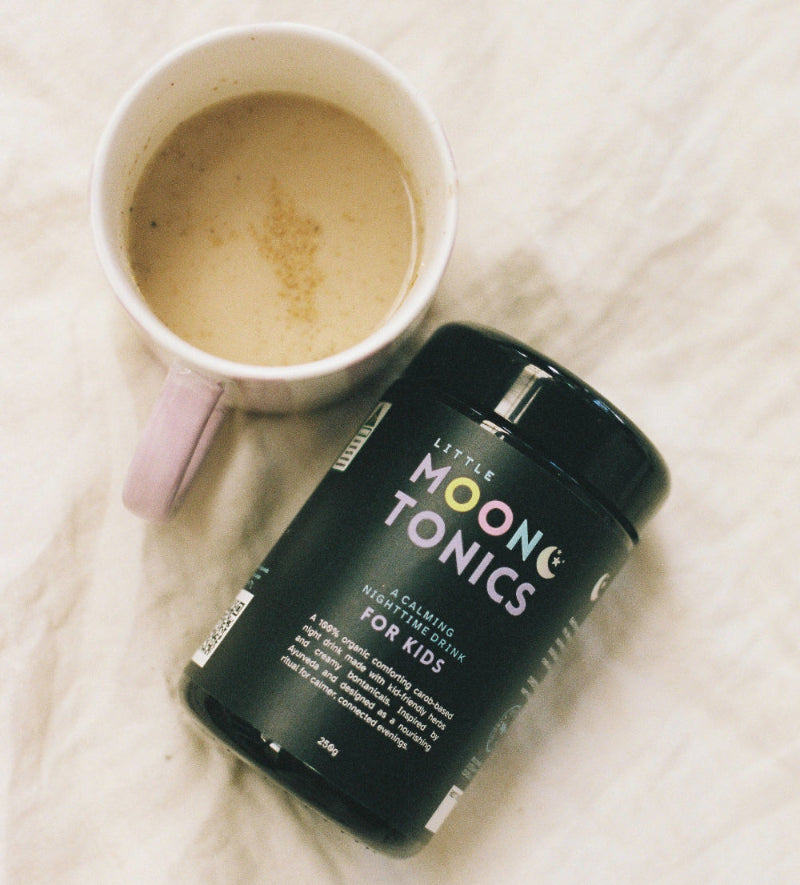 a jar of little moon tonics rests next to a mug of tonic